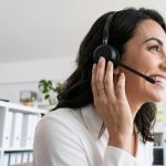 Mulher usando headset em um escritório durante atendimento ao cliente por telefone.